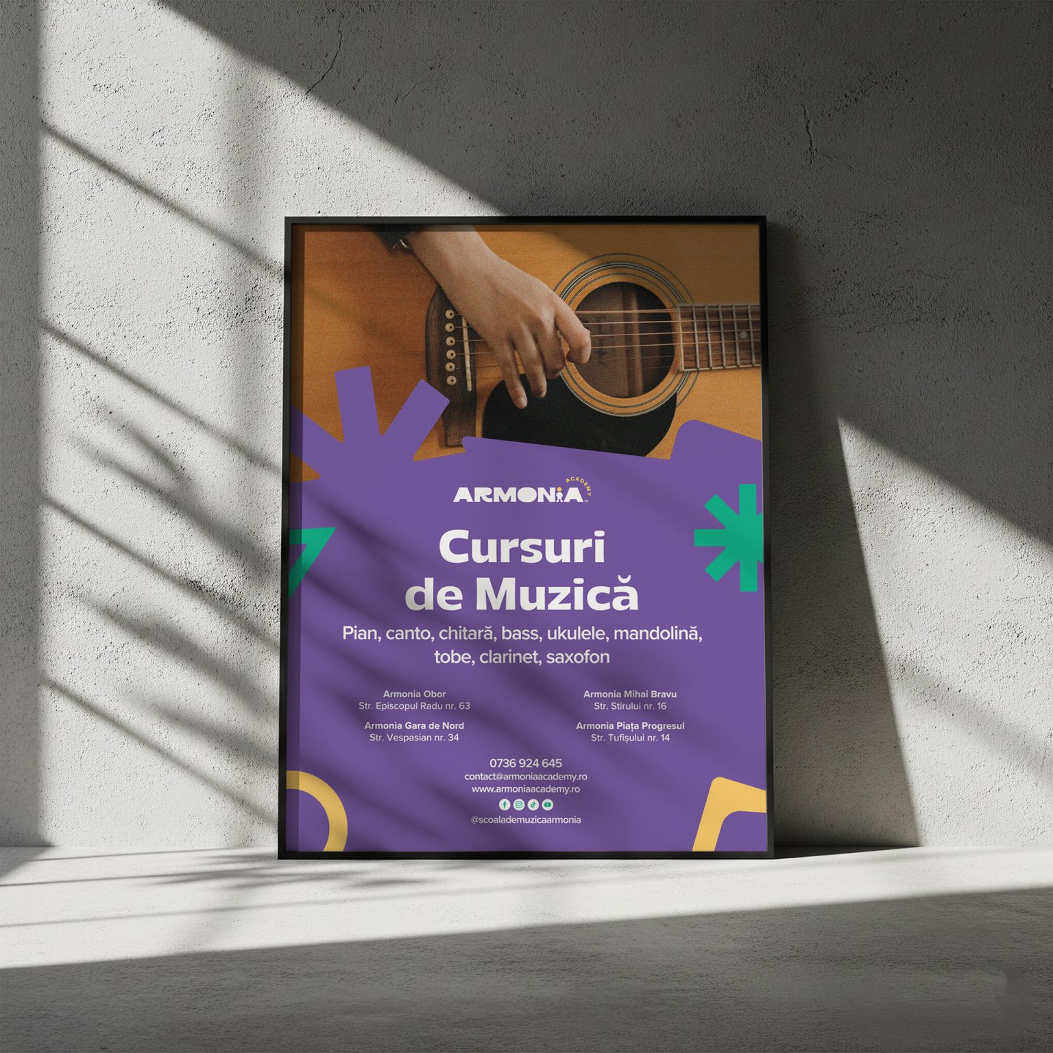 Afișul „Cursuri de muzică” înrămat, sprijinit de un perete de beton