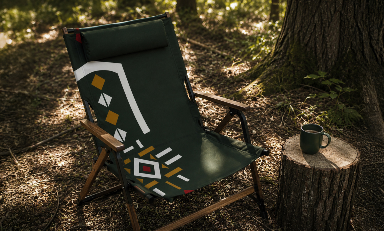 Dark green folding camp chair with the festival emblem enlarged across the fabric, beside a tree trunk